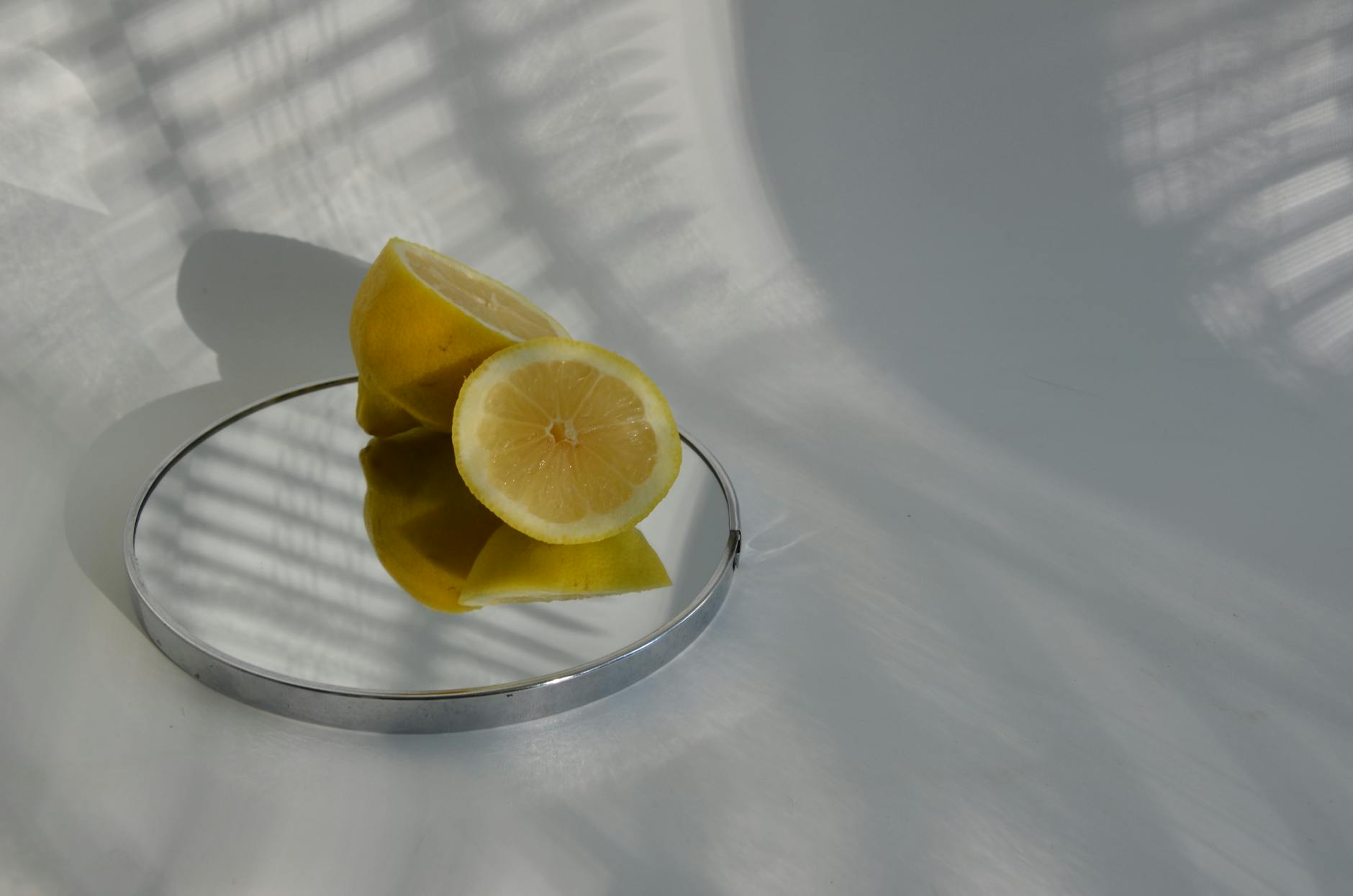 A teal clitoral vibrator on white silk fabric, representing modern pleasure technology