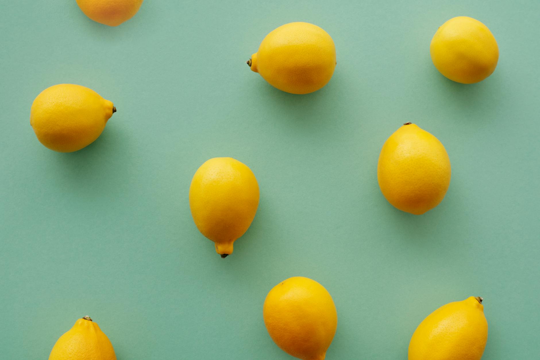 Bright yellow lemons on a soft green background, symbolizing the fresh approach to choosing the right lemon vibrator setting.